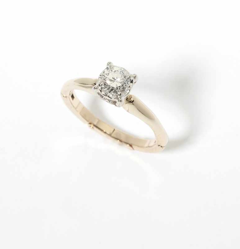 Appraisal: A diamond and gold solitaire ring Centering a round brilliant-cut