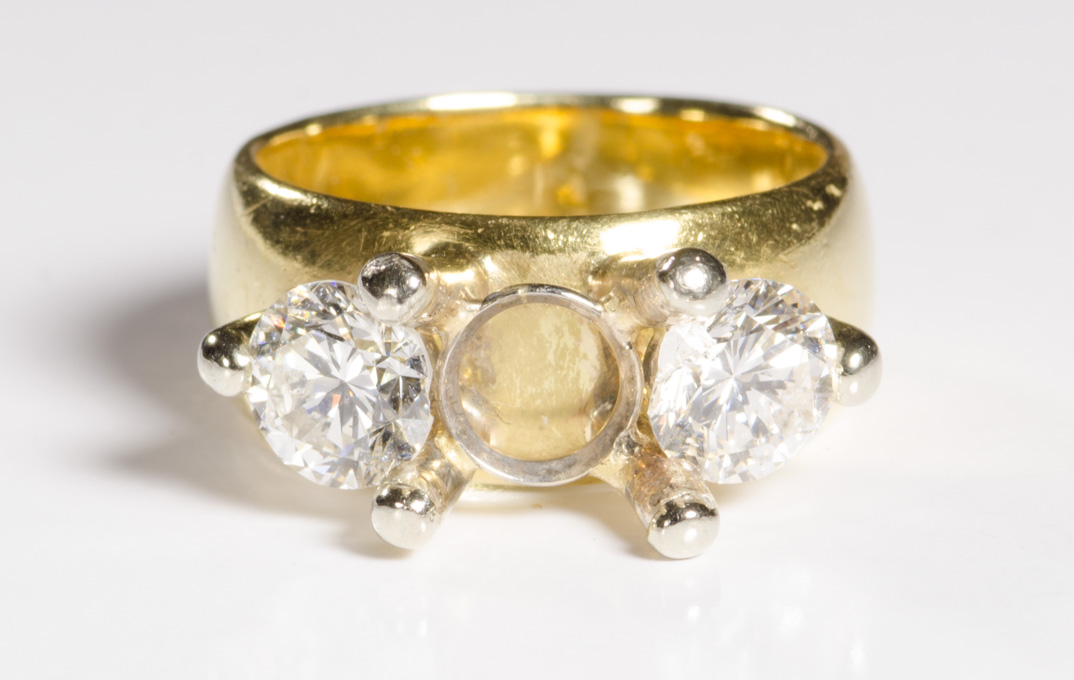 Appraisal: A DIAMOND AND EIGHTEEN KARAT GOLD RING with missing center