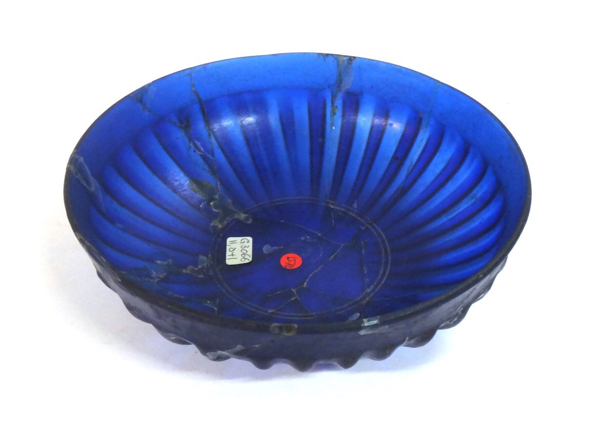 Appraisal: A Persian blue glass bowl with radiating ribbed design to