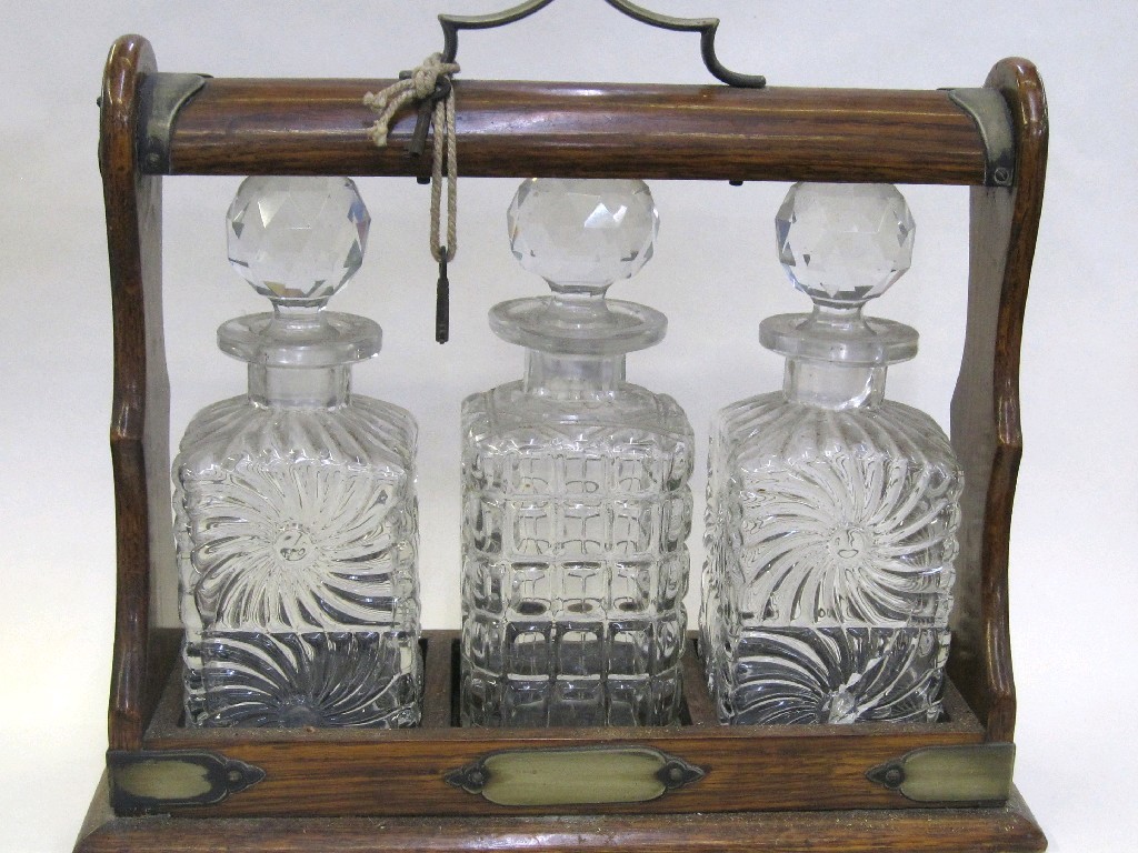 Appraisal: Oak tantalus with three glass decanters and EP mounts