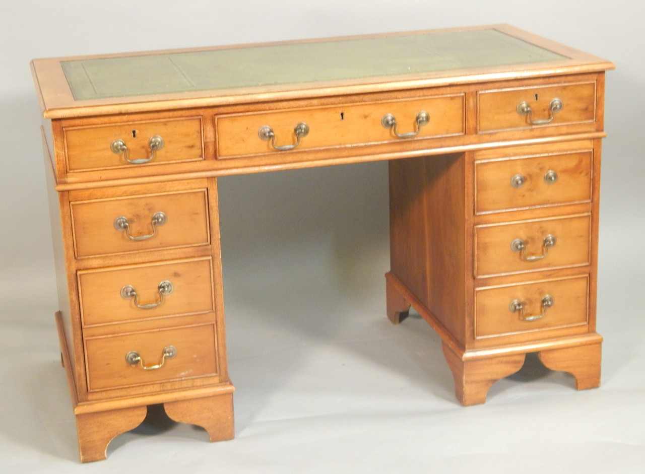 Appraisal: A reproduction yew pedestal desk the top with a green