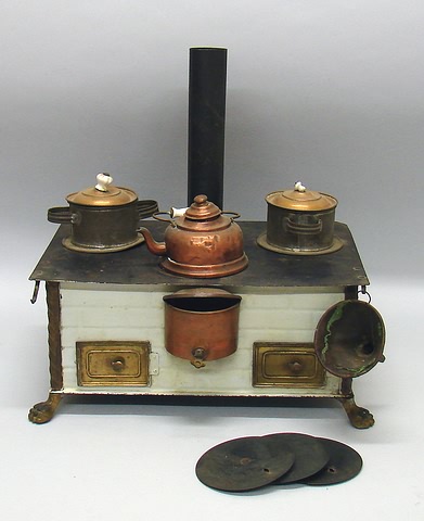 Appraisal: Footed doll size tin stove Decorated with a white finish