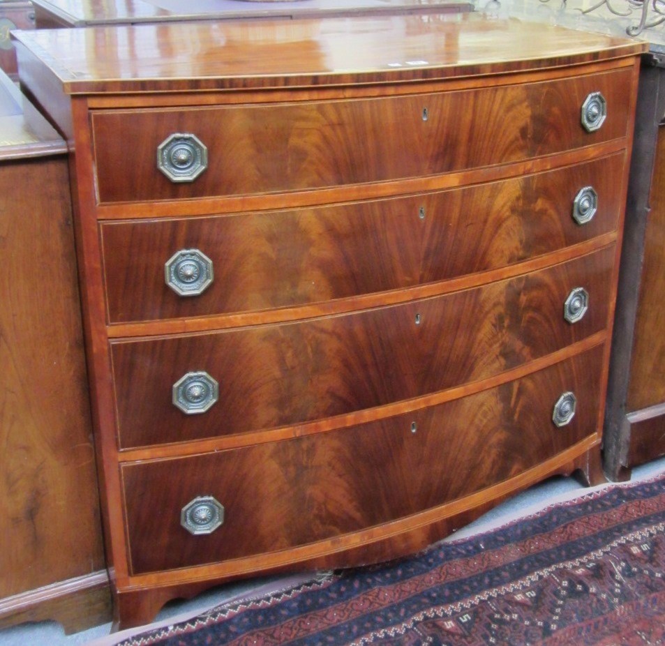 Appraisal: A George III crossbanded mahogany bowfront chest of four long