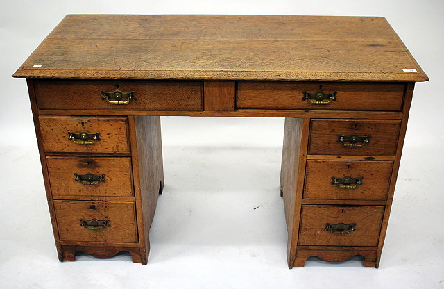 Appraisal: AN OAK KNEE HOLE DESK with eight drawers cm wide