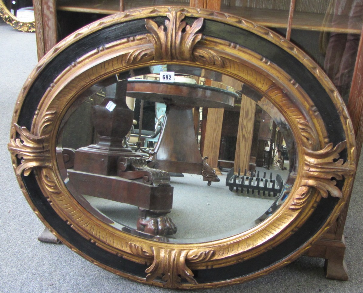 Appraisal: A th century French giltwood and ebonised oval wall mirror