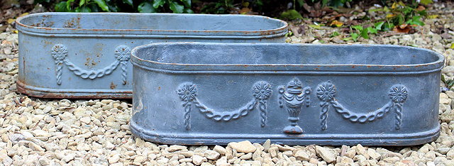 Appraisal: A PAIR OF GREY PAINTED CAST IRON PLANTERS with rounded