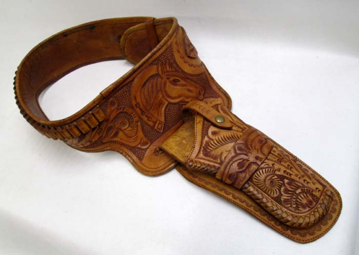 Appraisal: LEATHER GUN BELT AND HOLSTER tan hand tooled leather featuring