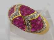 Appraisal: A ruby and diamond bombe ring set with panels of