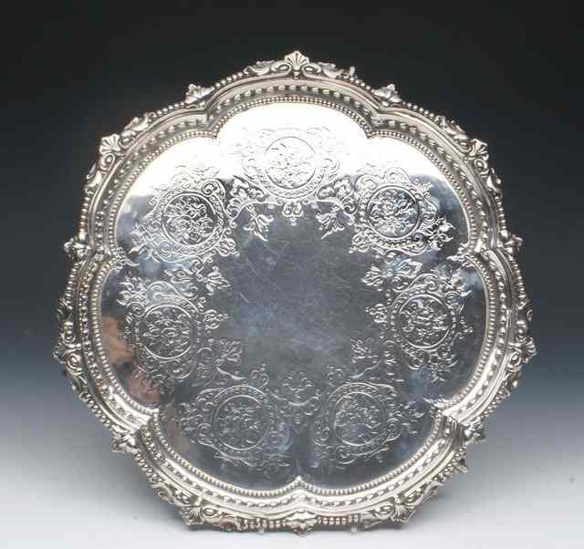 Appraisal: A VICTORIAN SILVER SALVER with gadrooned shell and scroll border