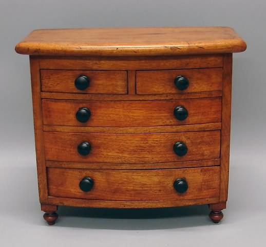 Appraisal: Swell front small drawers over wide drawers ebonized pulls urn-form