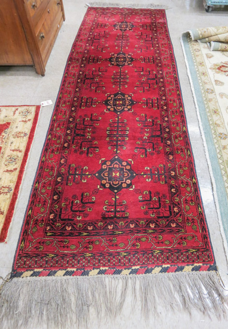 Appraisal: AFGHAN BELOUCHI TRIBAL RUNNER the red field decorated with four