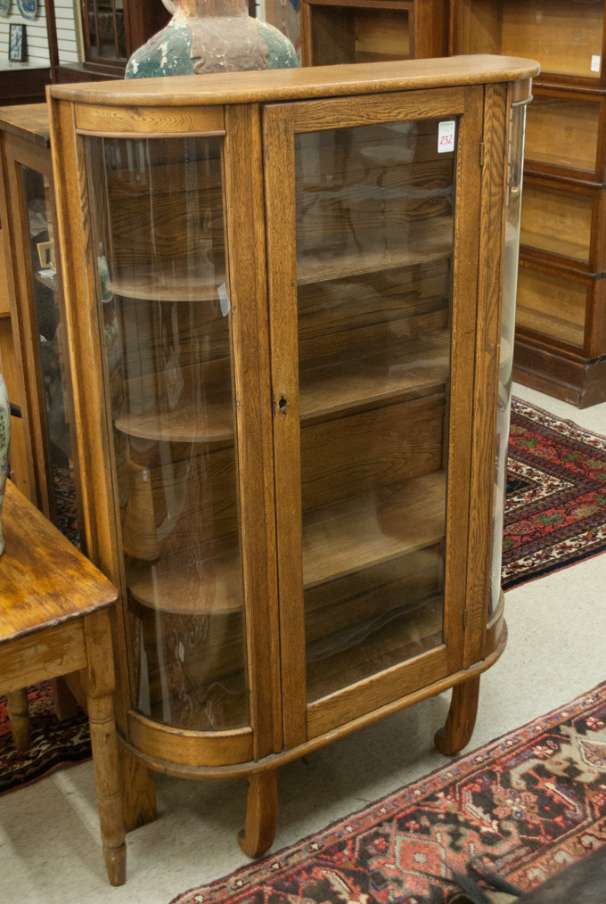 Appraisal: AN OAK AND CURVED GLASS CHINA CABINET American c H