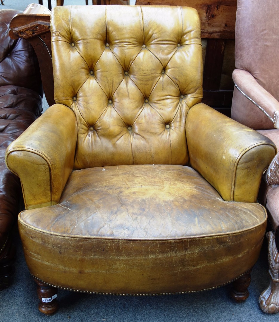 Appraisal: A Victorian easy armchair with tan leather upholstery on turned