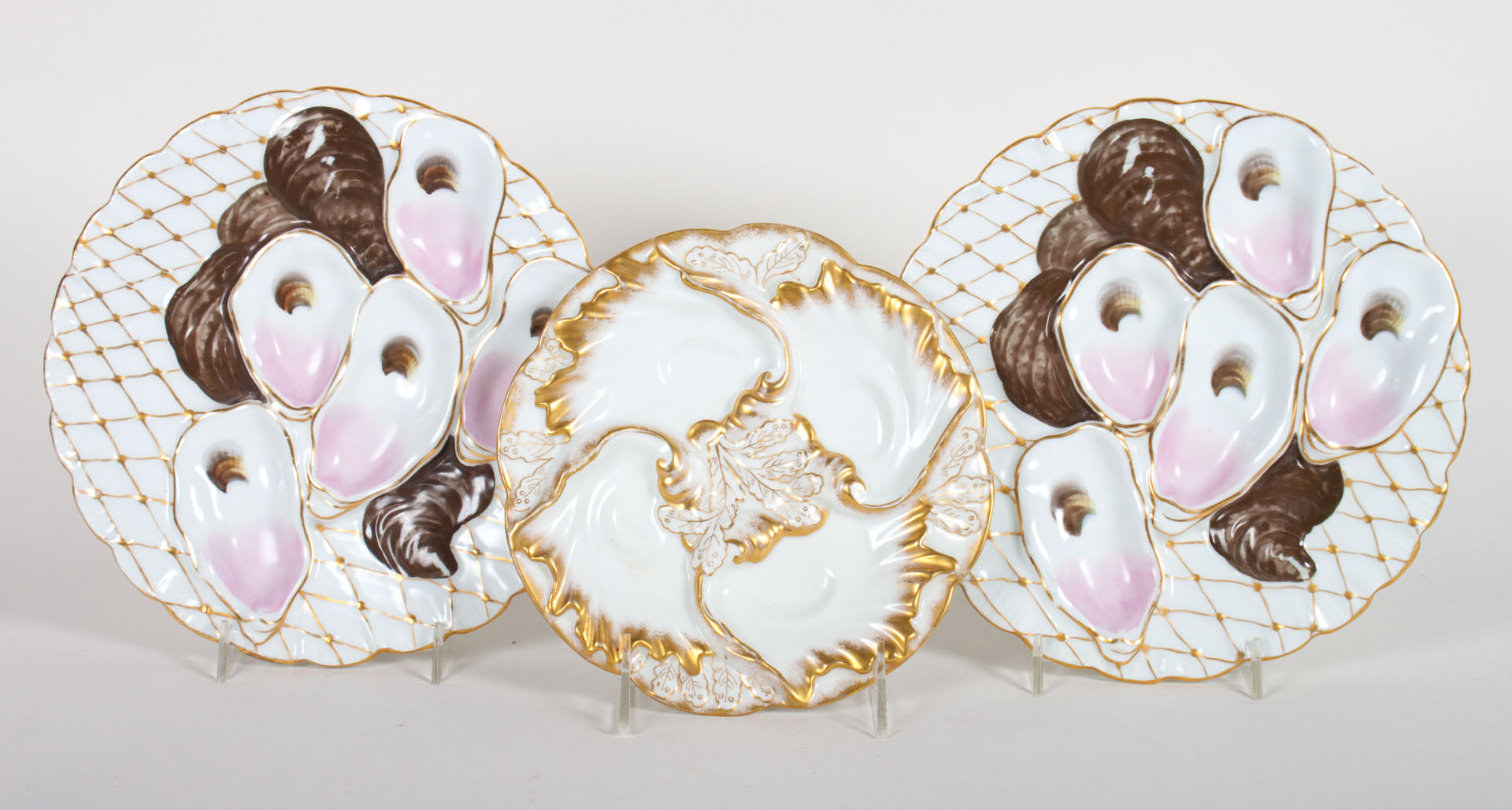 Appraisal: Three painted parcel-gilt porcelain oyster plates early th century pair