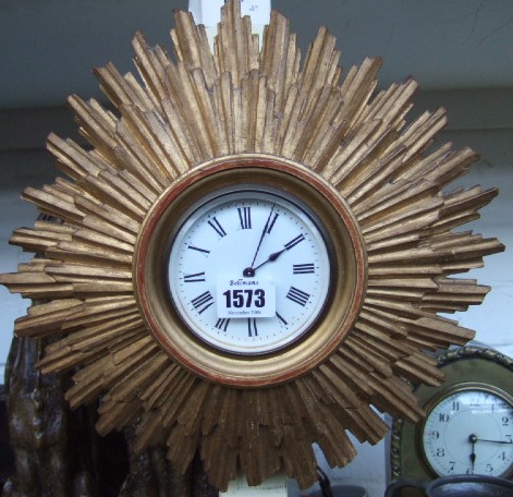 Appraisal: A gilt wood carved sunburst wall clock and a black