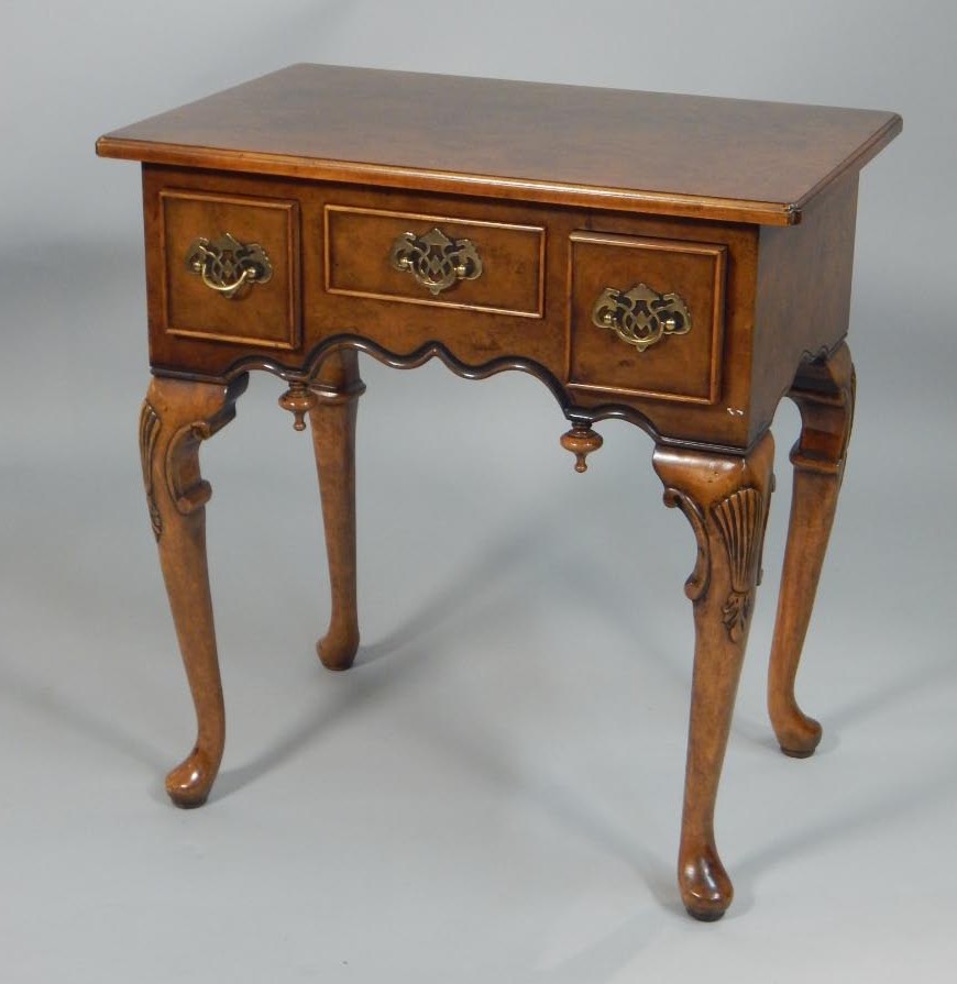 Appraisal: A reproduction walnut lowboy the rectangular top above three frieze