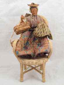 Appraisal: A peddlers doll seated in wicker chair approx cm high