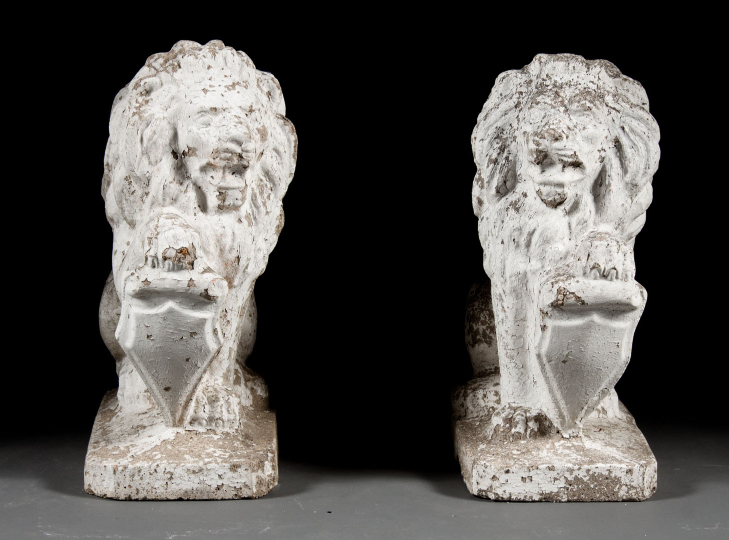 Appraisal: Pair of cast stone lions each modeled as lion holding