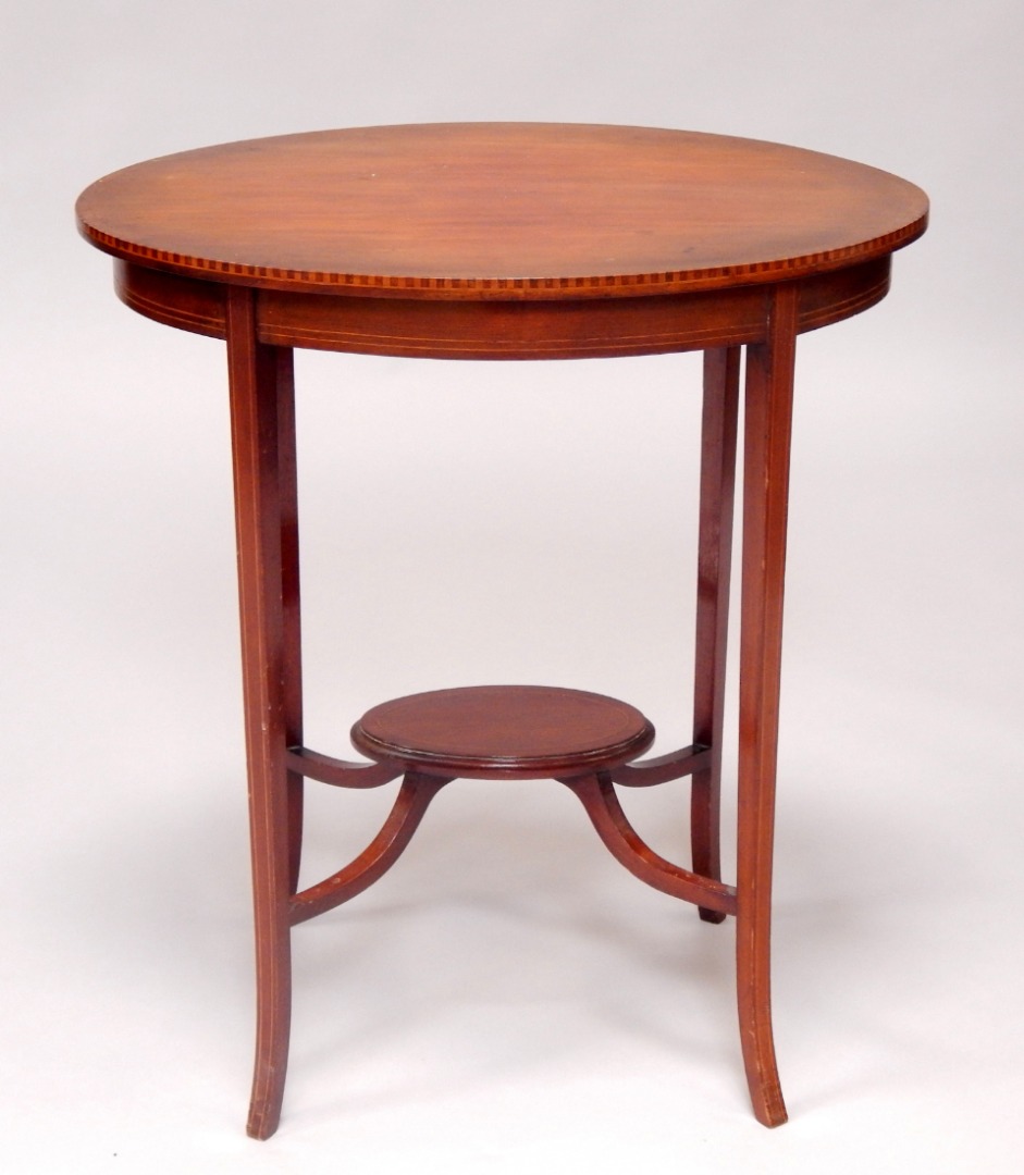 Appraisal: An Edwardian mahogany and crossbanded oval two tier occasional table