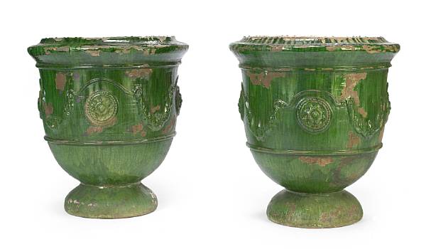 Appraisal: A pair of glazed earthenware urns Each with ovoid body