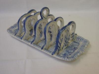 Appraisal: AN ENGLISH STONEWARE TOAST RACK of rounded oblong form with