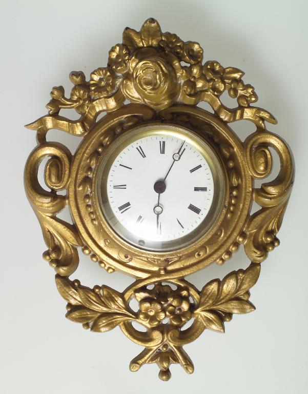 Appraisal: GILDED METAL CARTEL CLOCK circular white enamelled dial timepiece spring