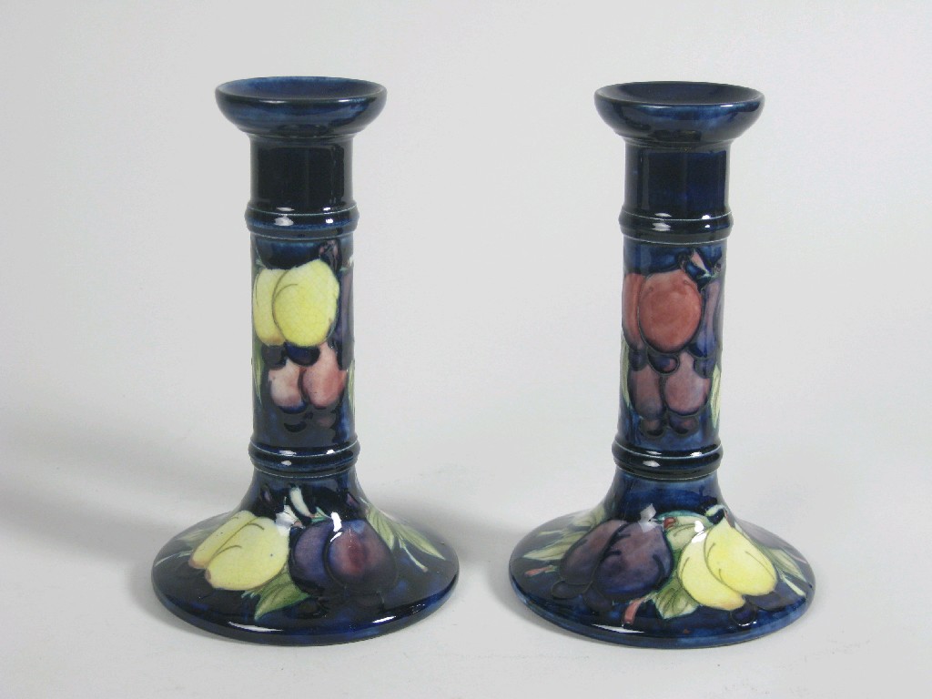 Appraisal: A pair of Moorcroft Pillar Candlesticks Wisteria design on a