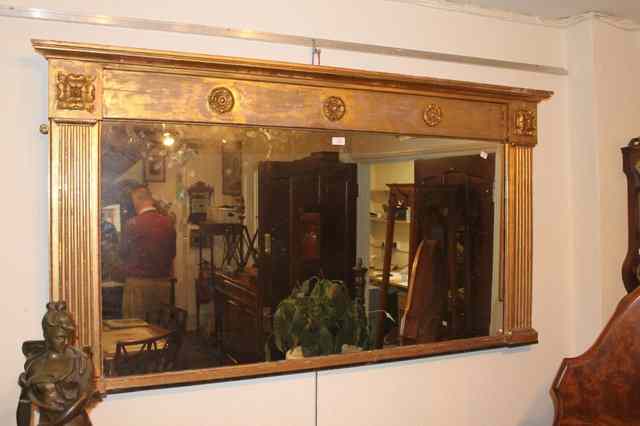 Appraisal: A REGENCY GILT OVERMANTLE MIRROR with applied rosettes and column