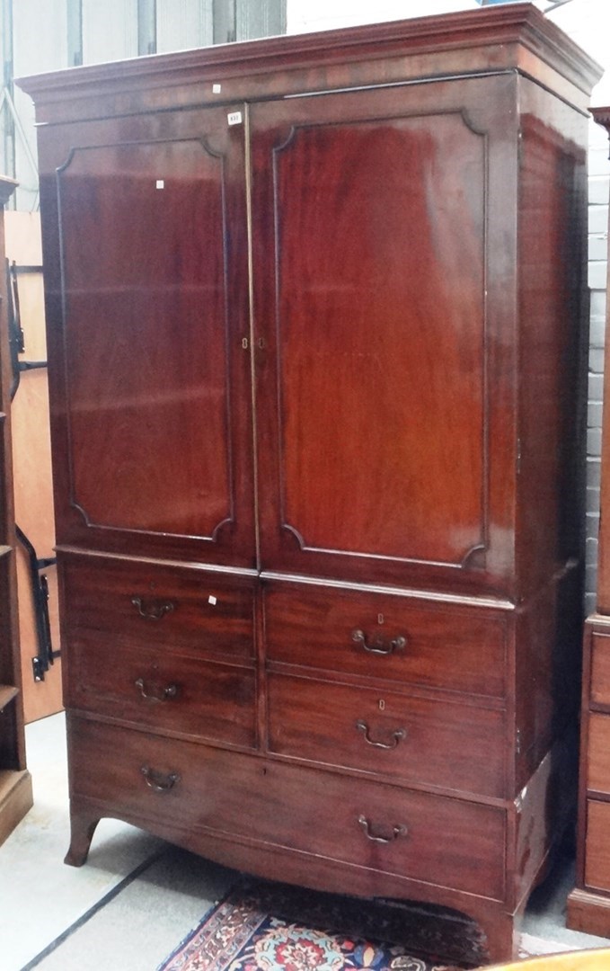 Appraisal: A George III mahogany wardrobe the moulded cornice over a