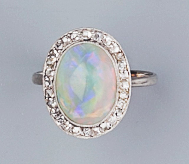 Appraisal: AN OPAL AND DIAMOND CLUSTER RING the oval cabochon opal