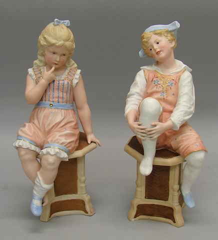 Appraisal: Pair of Marked Heubach bisque figurines sitting on pedestal tables