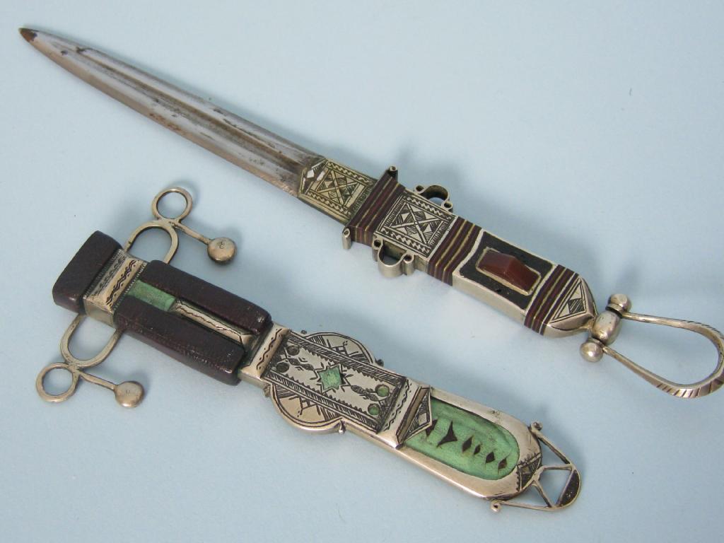 Appraisal: A white metal cased dagger with leather mounts and inset