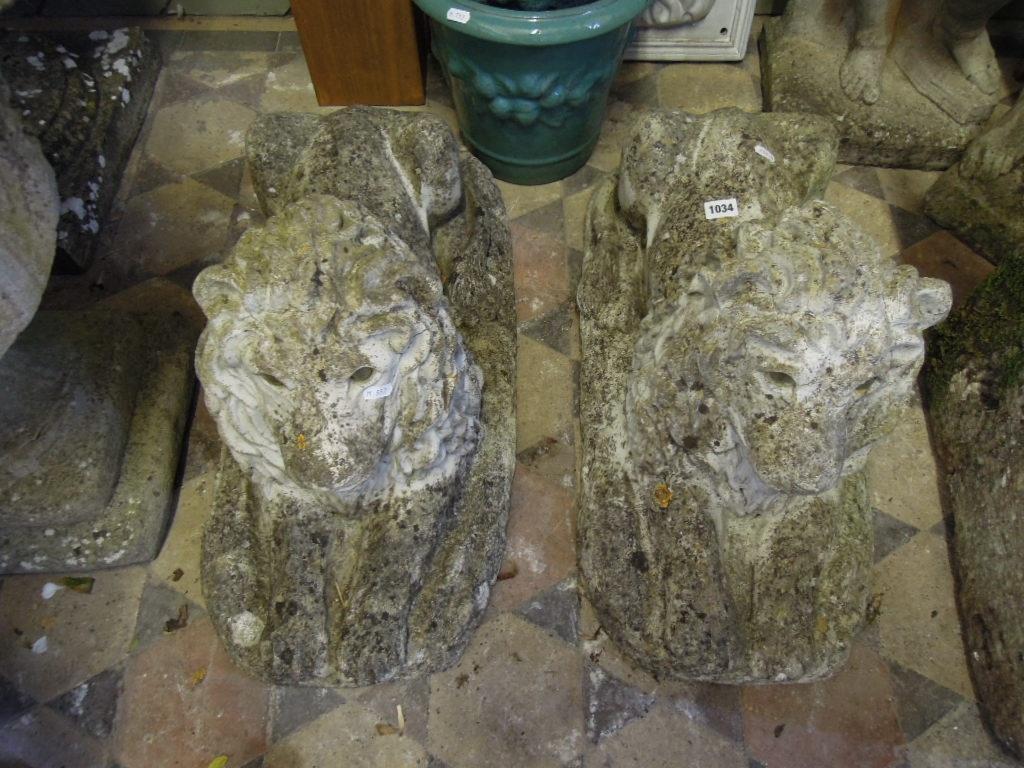 Appraisal: A pair of weathered composition stone recumbent lions with flowing