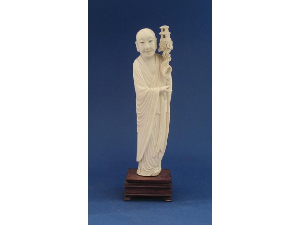 Appraisal: A CHINESE IVORY FIGURE OF AN IMMORTAL holding a pavilion