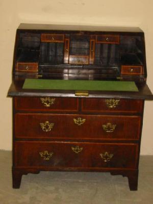 Appraisal: A GEORGIAN WALNUT AND FEATHER BANDED BUREAU the fallfront enclosing