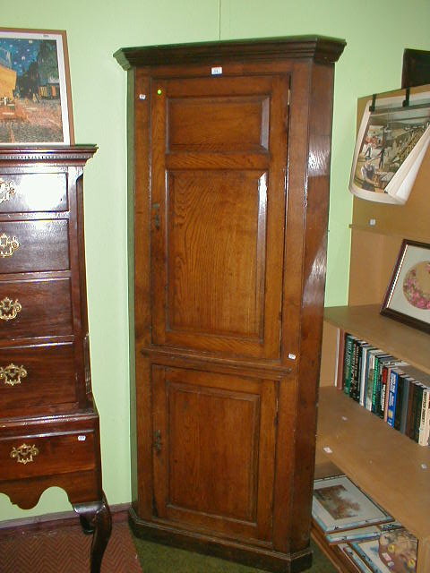 Appraisal: A Georgian oak and elm freestanding corner cupboard with fielded