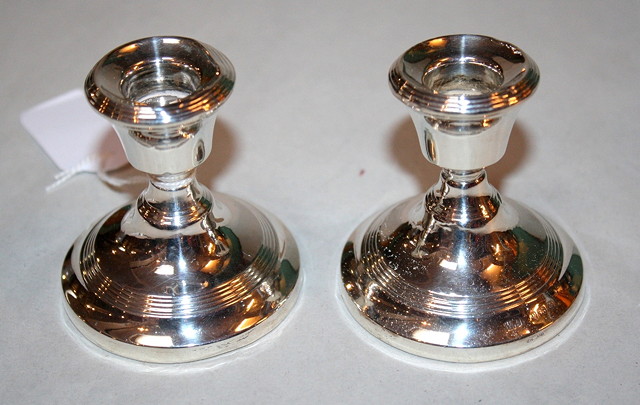 Appraisal: A PAIR OF SILVER DWARF CANDLESTICKS on turned stepped feet