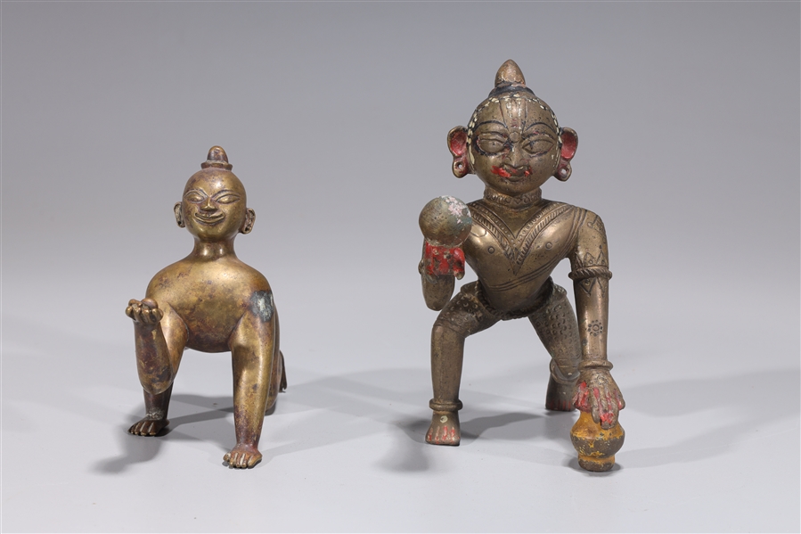 Appraisal: Two antique Indian bronze crawling Krishna statues with enamel and