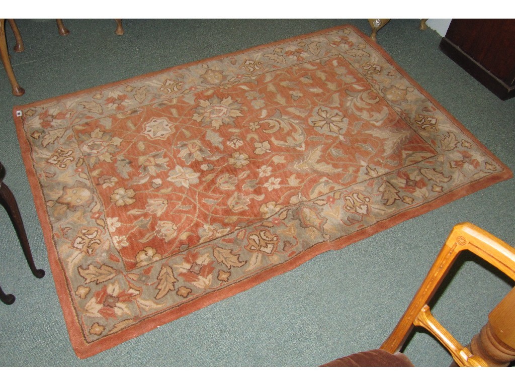 Appraisal: Floral floor rug on an orange ground