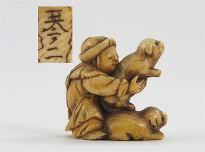 Appraisal: A Japanese ivory netsuke carved as a boy clutching two