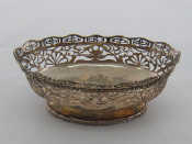 Appraisal: An oval silver basket with pierced steep sides on spread