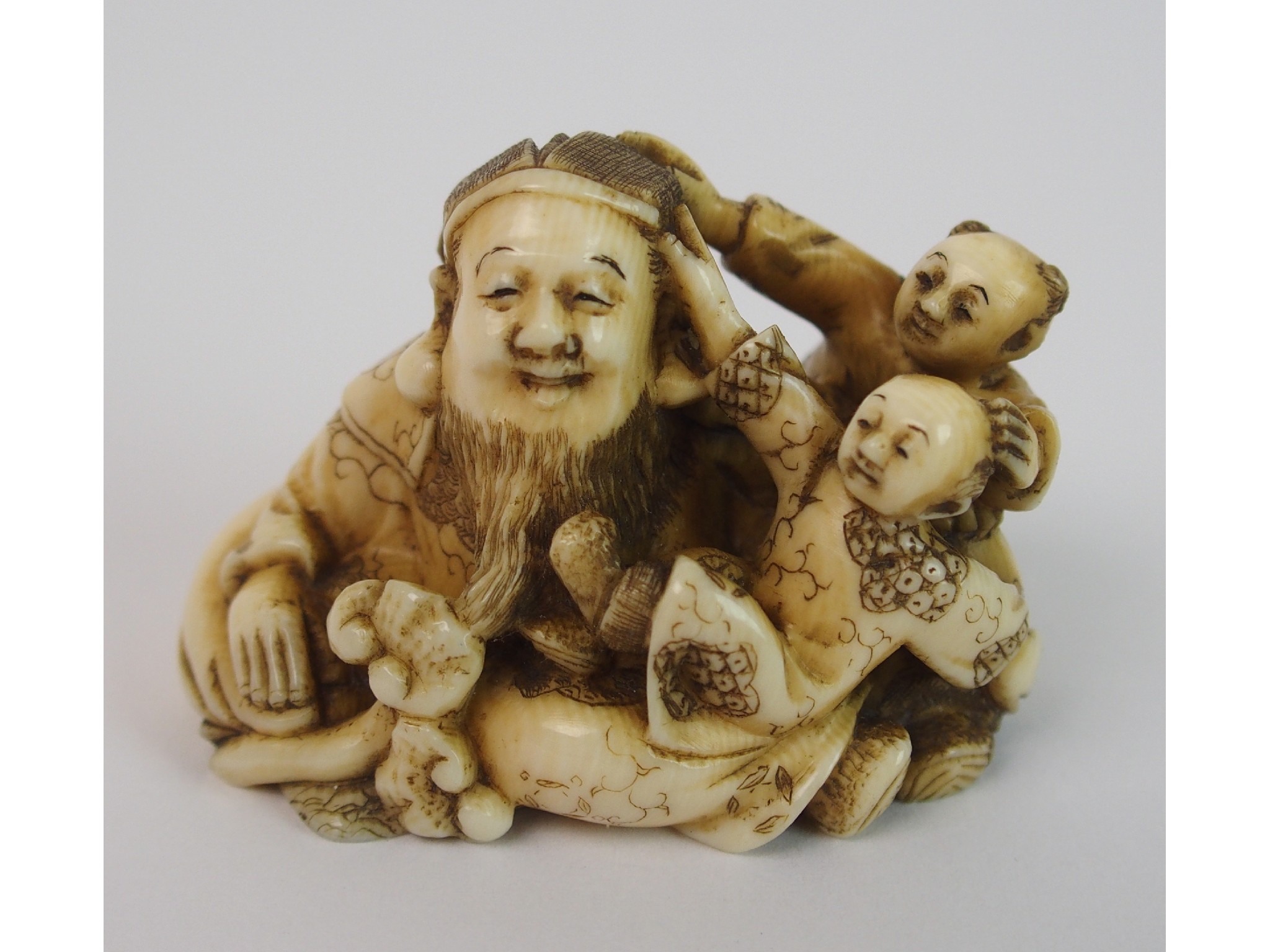 Appraisal: A Japanese ivory netsukecarved with a father and two children