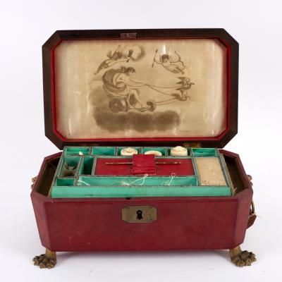 Appraisal: A Regency leather covered sewing box with brass lion mask