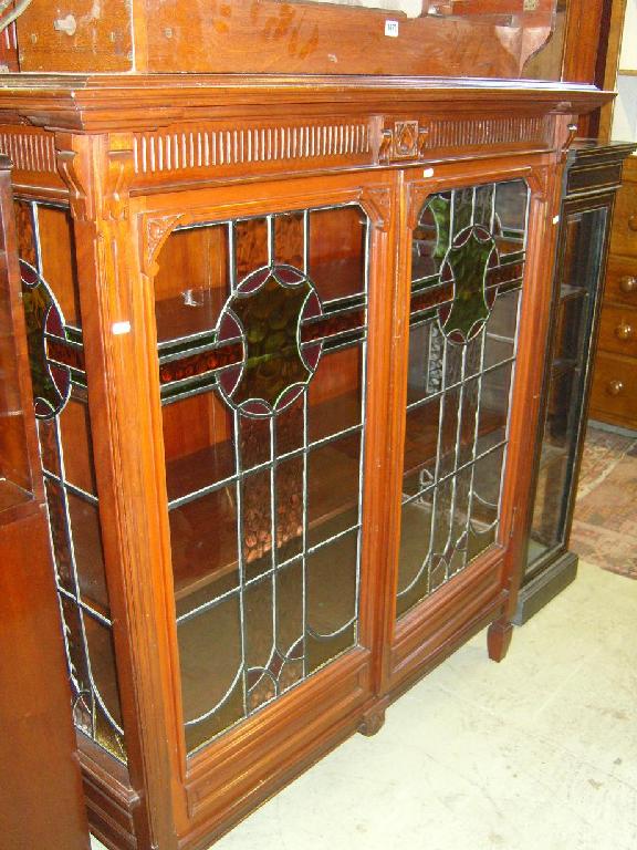 Appraisal: An Edwardian walnut side cabinet with raised back enclosed by