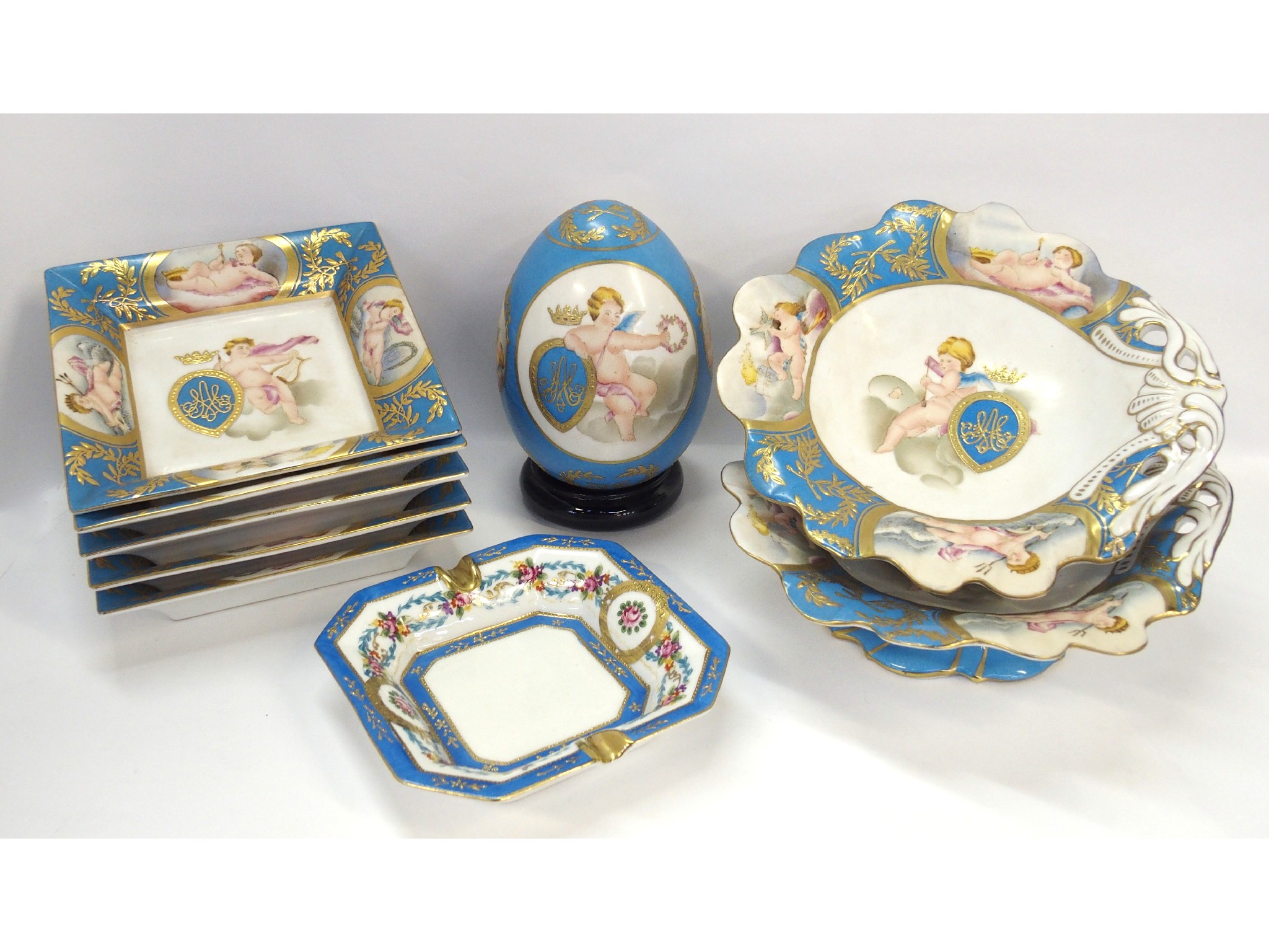 Appraisal: A pair of cherub decorated comports five matching square plates