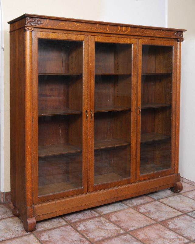 Appraisal: GOLDEN OAK CARVED BOOKCASE Early th century pediment with applied