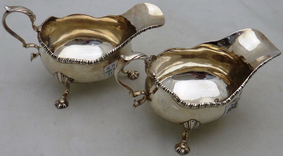 Appraisal: Two similar silver sauce boats each decorated with a shaped