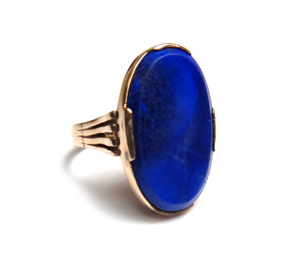 Appraisal: A gold ring mounted with an oval simulated lapis lazuli