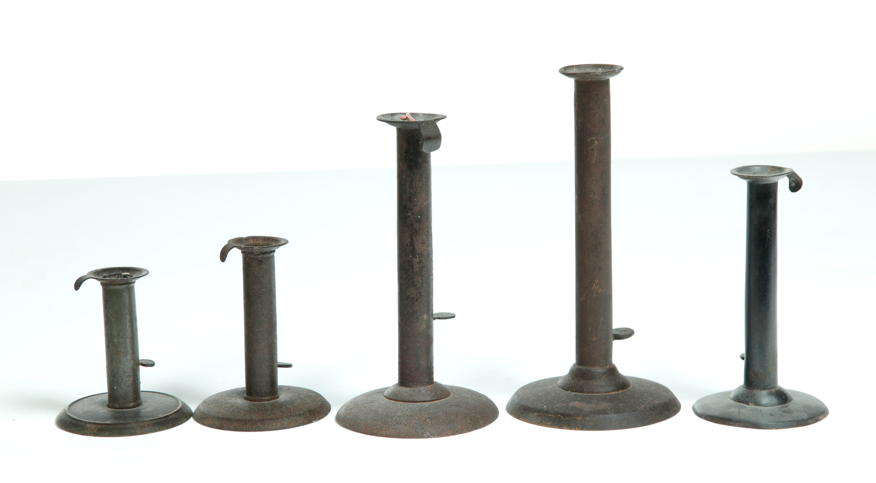 Appraisal: FIVE HOGSCRAPER CANDLESTICKS American or English mid th century One