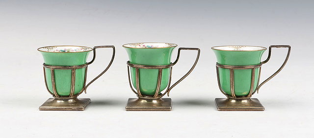 Appraisal: THREE PORCELAIN CUPS with silver holders standing on square bases